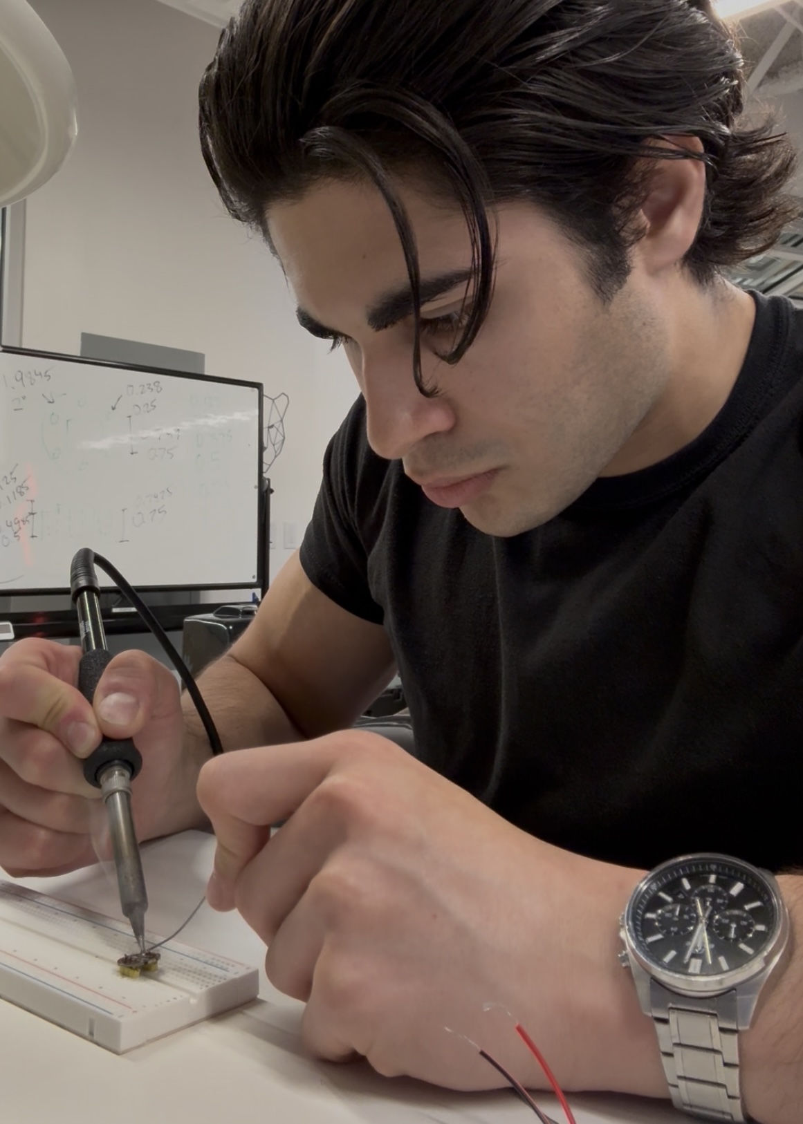Sam Potozkin soldering a circuit in the lab